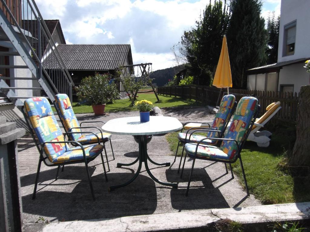 eine Terrasse mit einem Tisch, Stühlen und einem Sonnenschirm in der Unterkunft Ferienwohnung Luzia in Eichstegen