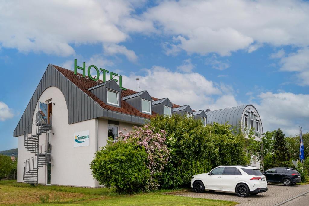 ein Hotel mit einem davor geparkten Auto in der Unterkunft Hotel SunParc - SHUTTLE zum Europa-Park Rust 4km & Rulantica 2km in Ringsheim
