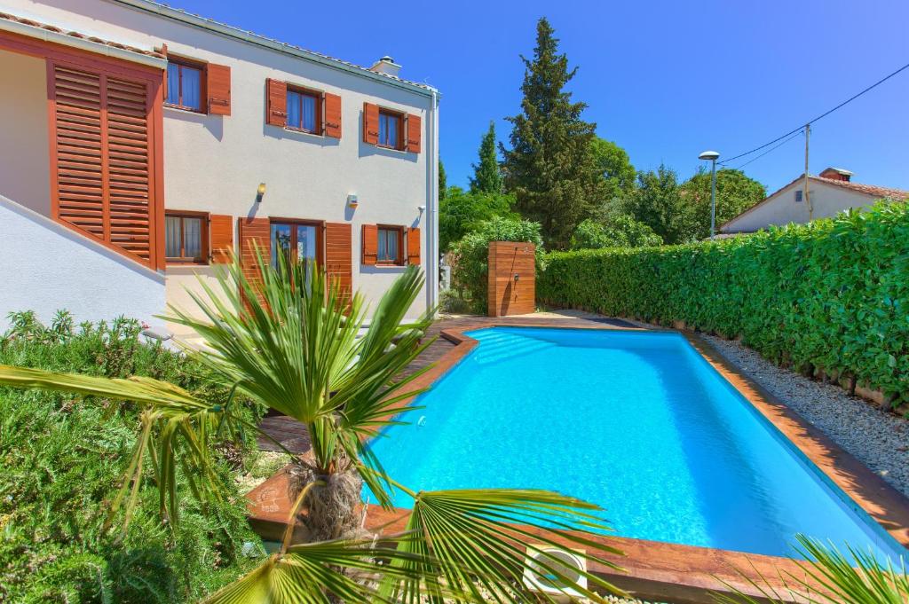 a swimming pool in front of a house at Villa San Vista with pool in Sveti Vid-Miholjice