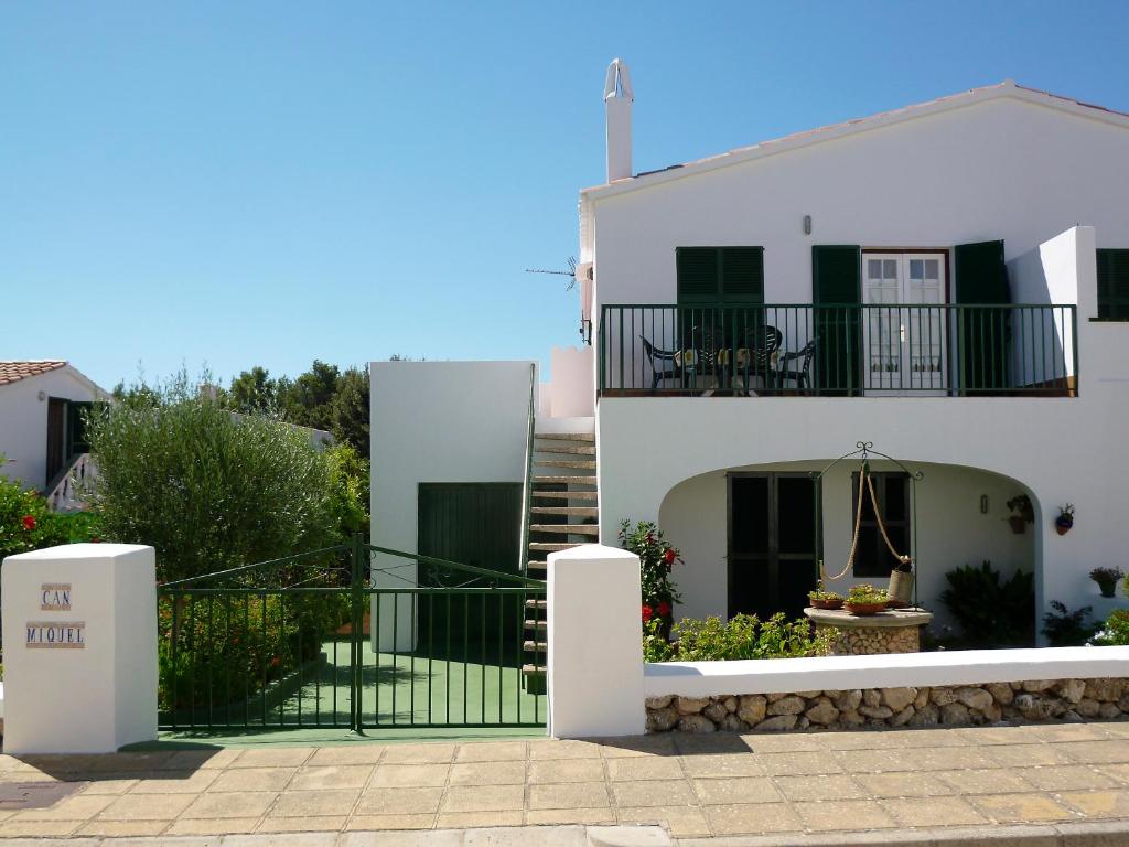 uma casa branca com uma escada e uma varanda em Apartamento 2ª planta Ca'n Miquel em Cala Galdana