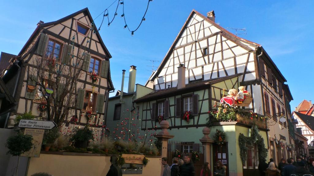 a group of half timbered houses in a street at La Tour Enchantée in Ribeauvillé