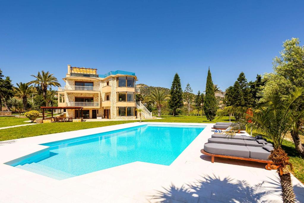 a villa with a swimming pool in front of a house at Vamavi Maison - Villa with Private Pool, Salamina in Salamina