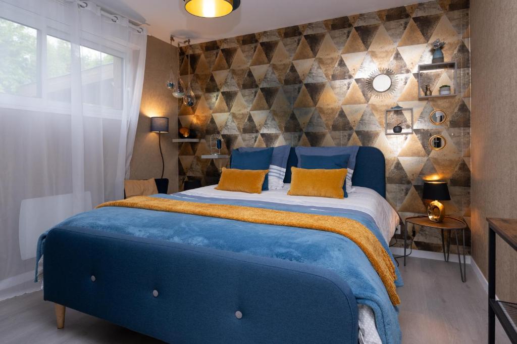 a blue bed in a bedroom with a stone wall at La Chambre Loft in Hennebont