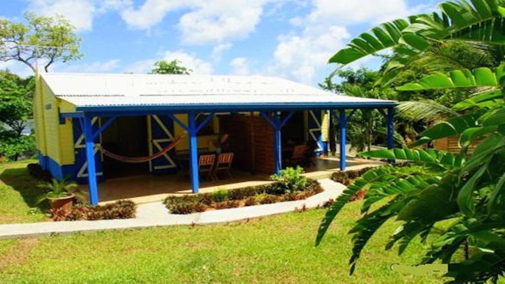 une petite maison avec un kiosque bleu dans l'établissement Residence Les Palmiers, à La Trinité