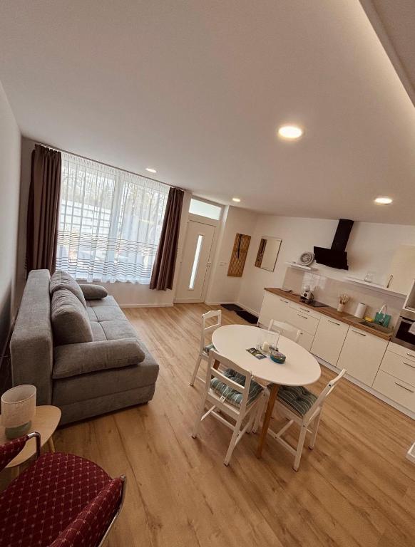a living room with a couch and a table at Theodora Apartman in Zánka