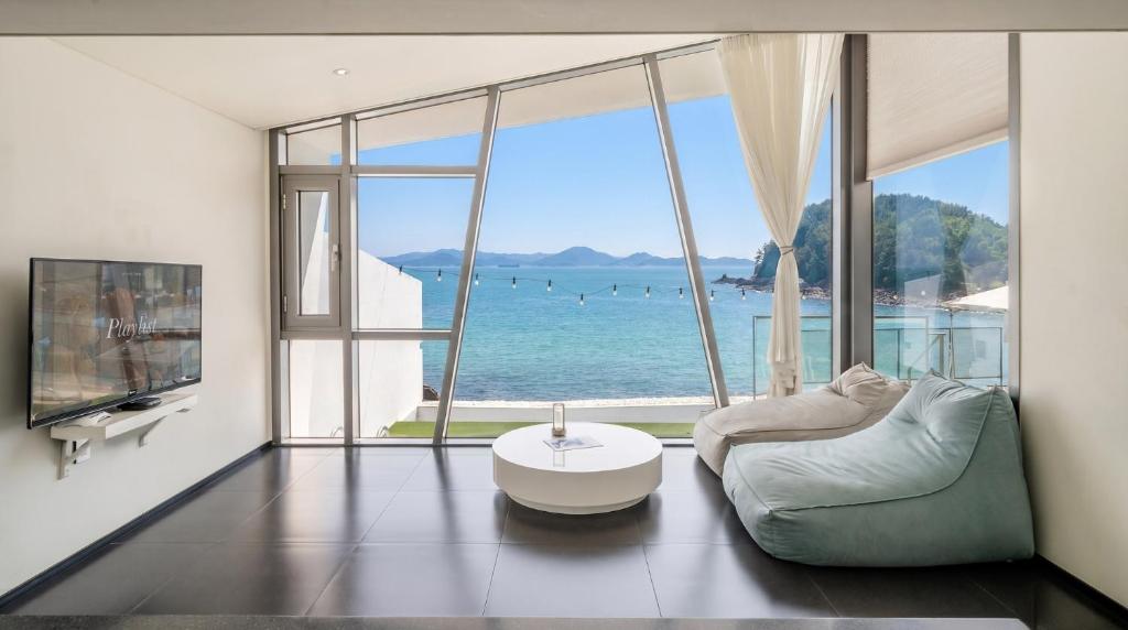 a living room with a view of the ocean at Namhae Pumda Pool villa Pension in Namhae