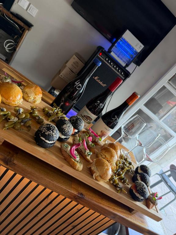 a table topped with different types of pastries and a bottle of wine at Logis Hôtel Auberge Lukaïna in Urrugne