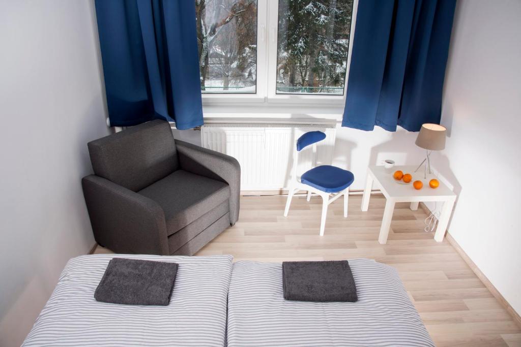um quarto com uma cama, uma cadeira e uma janela em Spa Górka em Szklarska Poręba