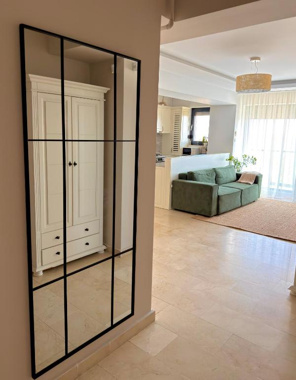 a large mirror in a living room with a couch at Sophia Luxury Residence in Mamaia
