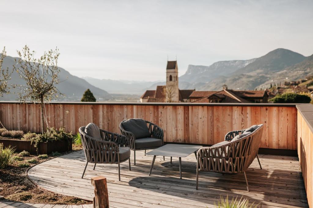 a wooden deck with chairs and a table on it at Eco Bnb & Apartments Bründlerhof in Marlengo