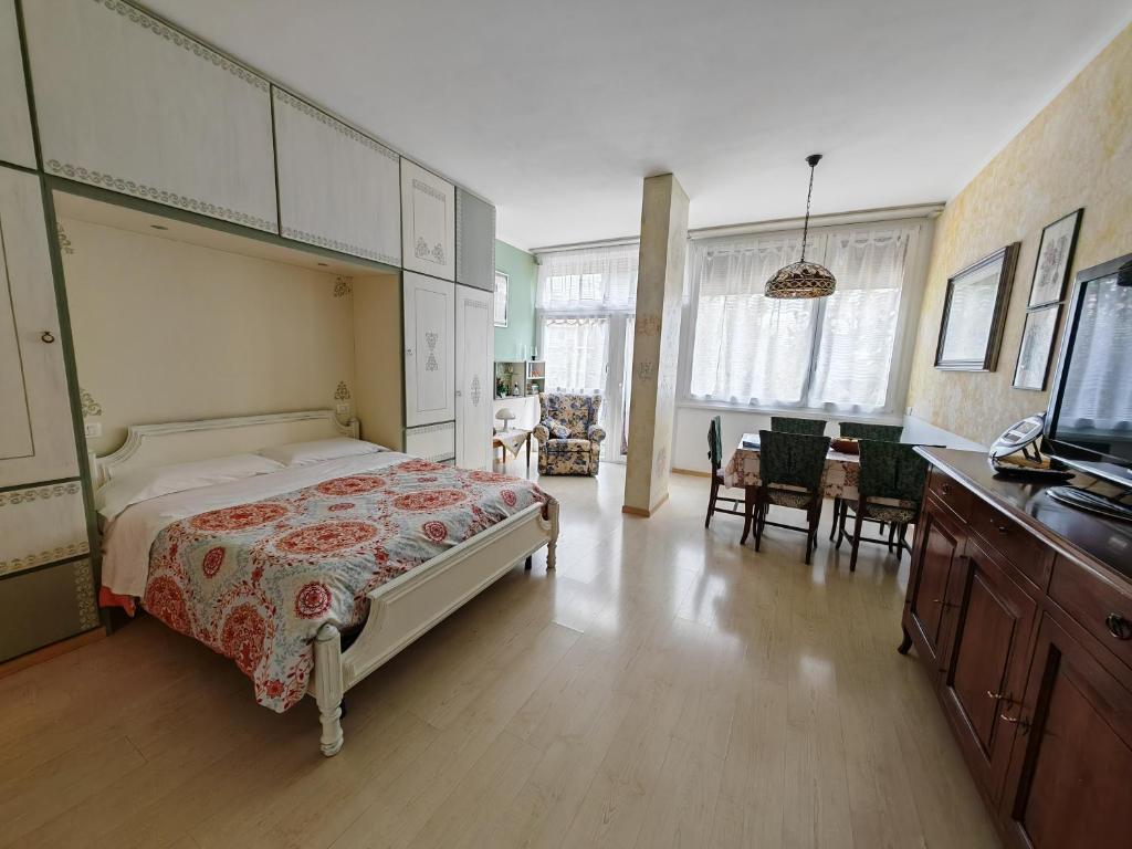 a bedroom with a large bed and a dining room at Garda Apartments in Euroresidence in Garda