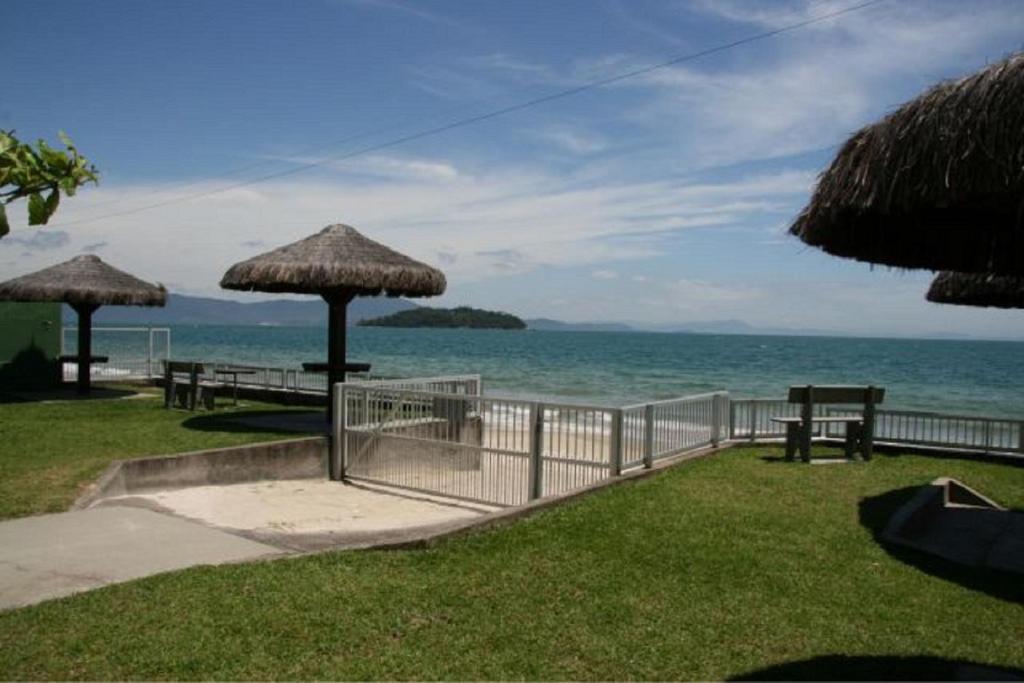 vistas a la playa con bancos y sombrillas en Triplex/ Cabana 08, en Florianópolis