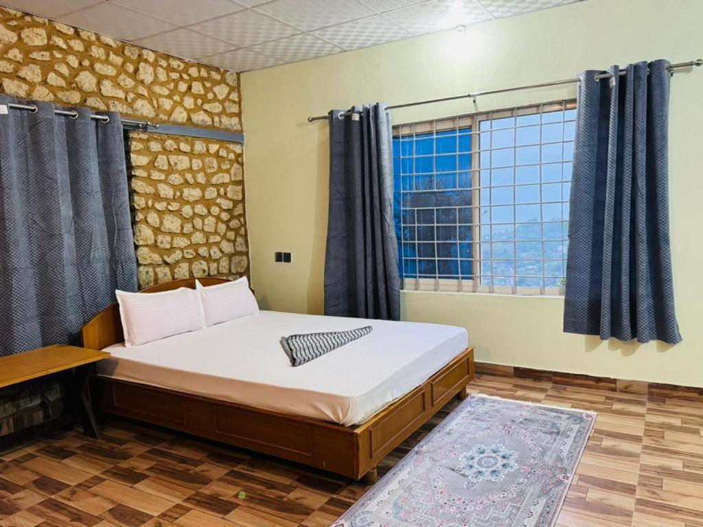 a bedroom with a large bed and a window at Tranquility Apartment in Pokhara