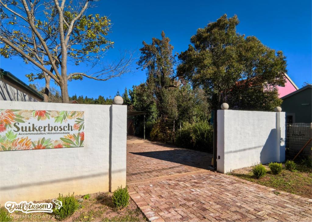 a gate to a house with a sign on it at Suikerbosch Room 1 and Room 2 in Dullstroom