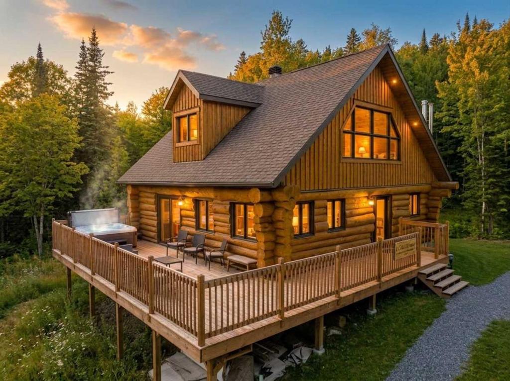 a large log cabin with a large deck at Spa & Pool table - Le Massif in Saint Adolphe D'Howard