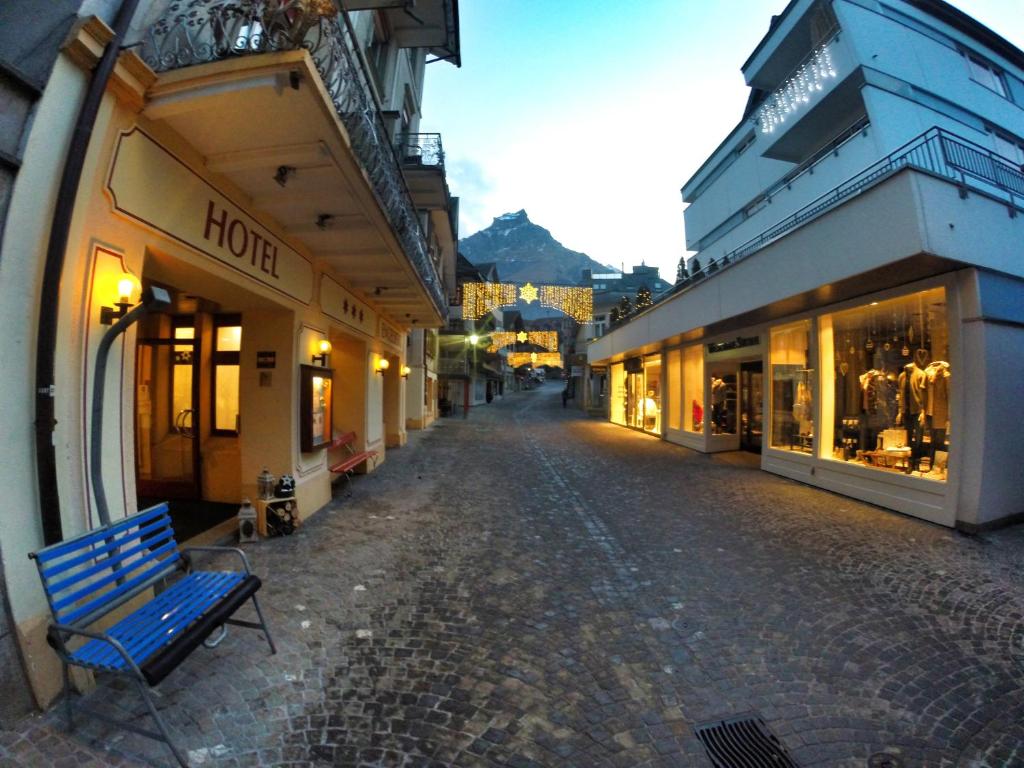 pusta ulica z niebieską ławką przed budynkami w obiekcie Hotel Engelberg "mein Trail Hotel" w mieście Engelberg