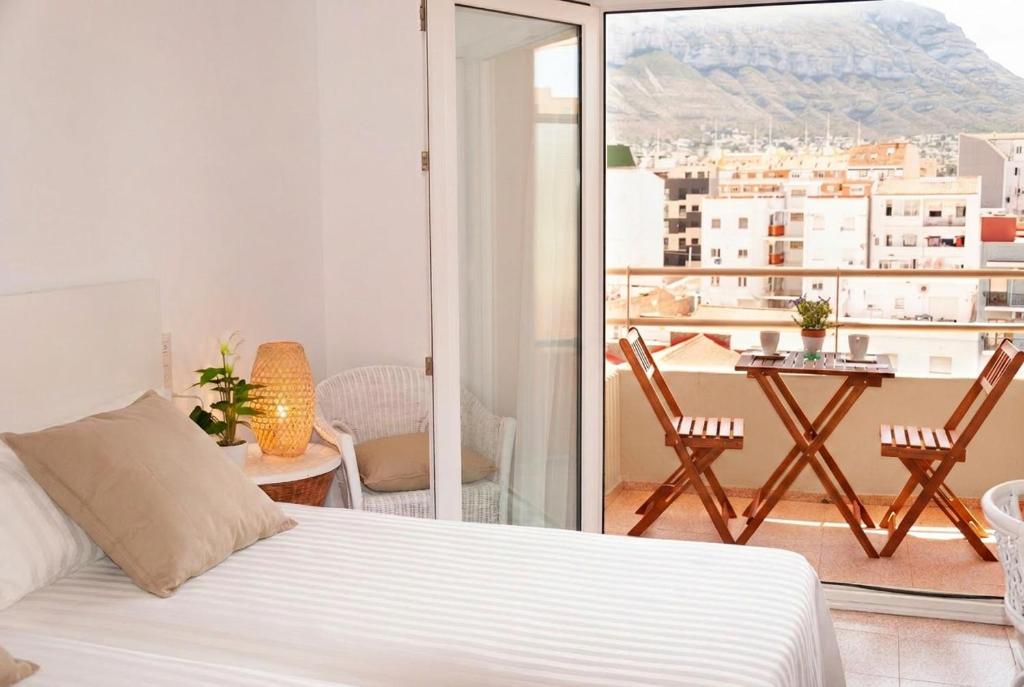 a bedroom with a bed and a balcony with a view at Hostal Comercio in Denia