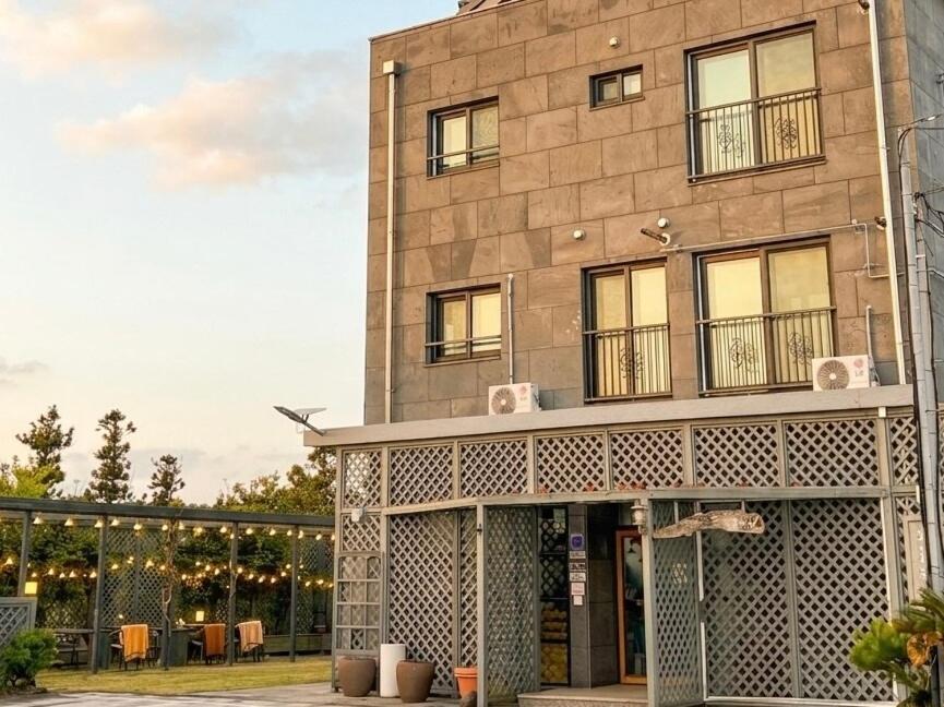 a tall brick building with windows and a balcony at 깨비하우스201 in Wŏlsan