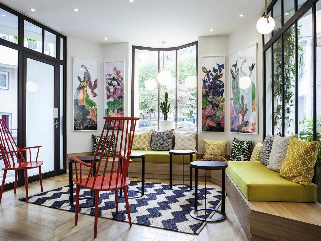 a living room with a yellow couch and red chairs at ibis Styles Paris Nation Porte De Montreuil in Paris