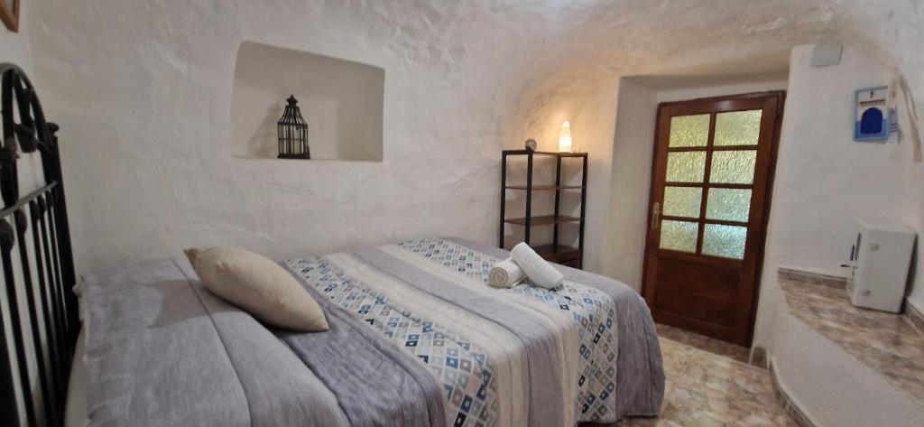 a bedroom with a bed in a white room at Casa Cueva Calatrava in Tabernas