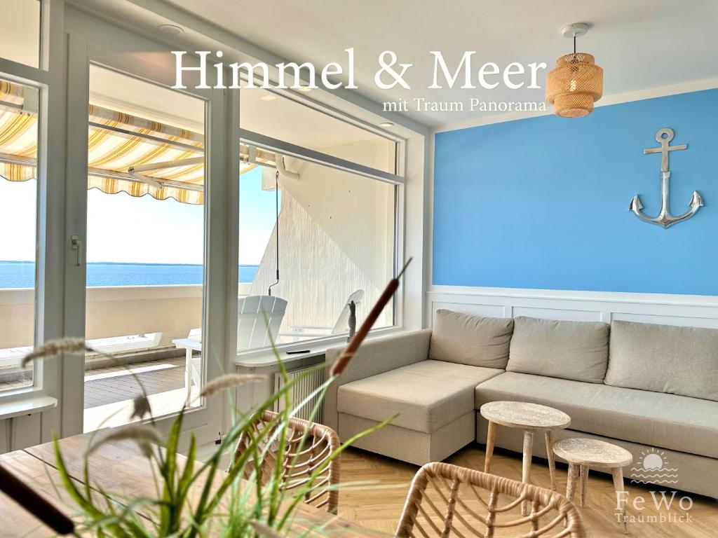 a living room with a couch and a view of the ocean at FeWo Traumblick - Himmel & Meer - TRAUM Panorama Meerblick, direkt am Strand mit großem Balkon in Sierksdorf
