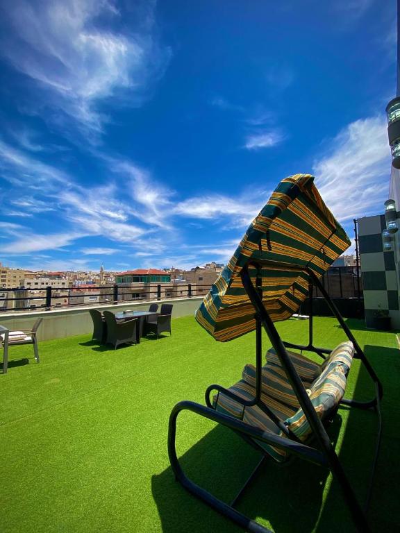 a chair with an umbrella on a roof at Al Mansi hotel in Amman