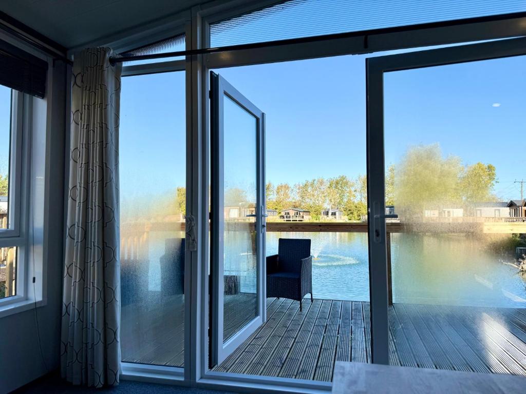 a screened in porch with a view of the water at Robin Lodge in Amotherby