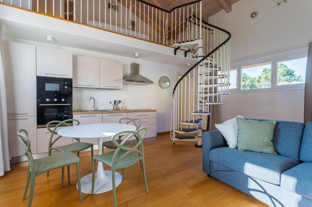 a living room with a blue couch and a table and chairs at Yourbanflat Ring River in Padova