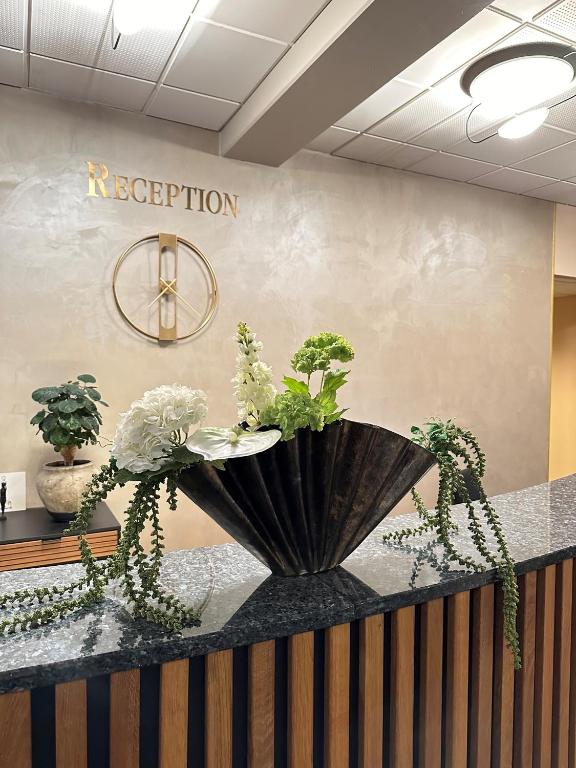 a reception counter with plants on top of it at Hotel Schaumburg in Holstebro