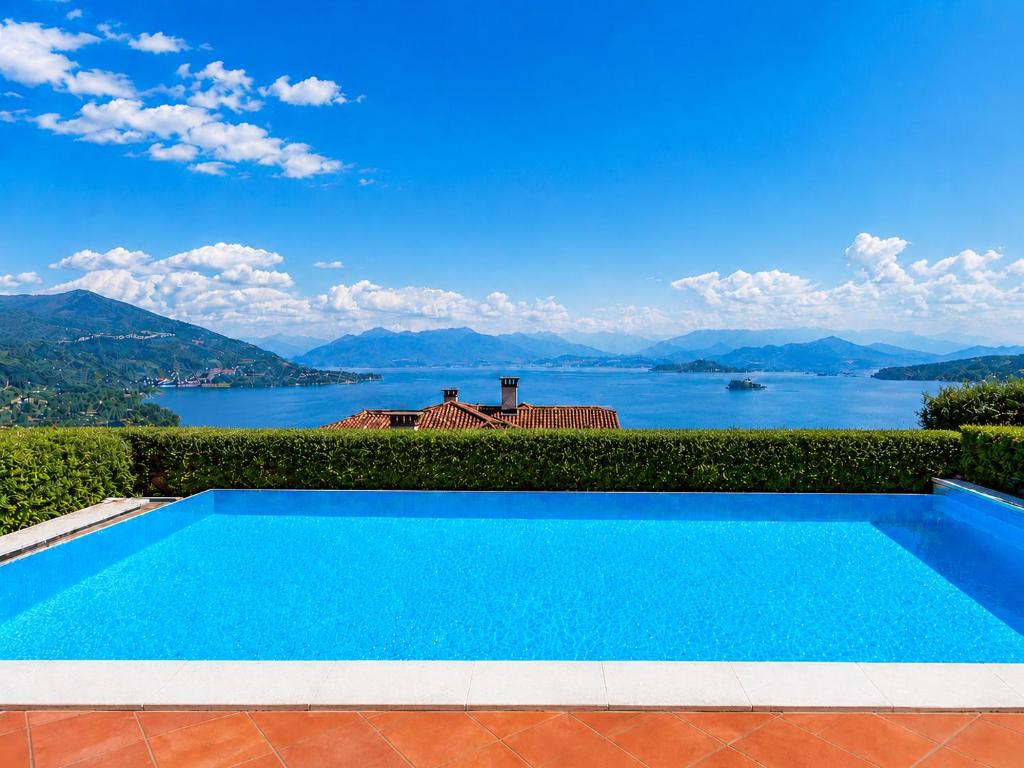 a swimming pool with a view of the water at Villa Marta in Meina