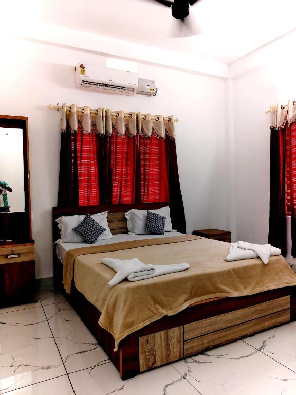 a bedroom with a large bed with red curtains at Blu Laguna Beach Homestay, Agatti Island, Lakshadweep - Only For Indian Nationals with valid entry permit in Agatti