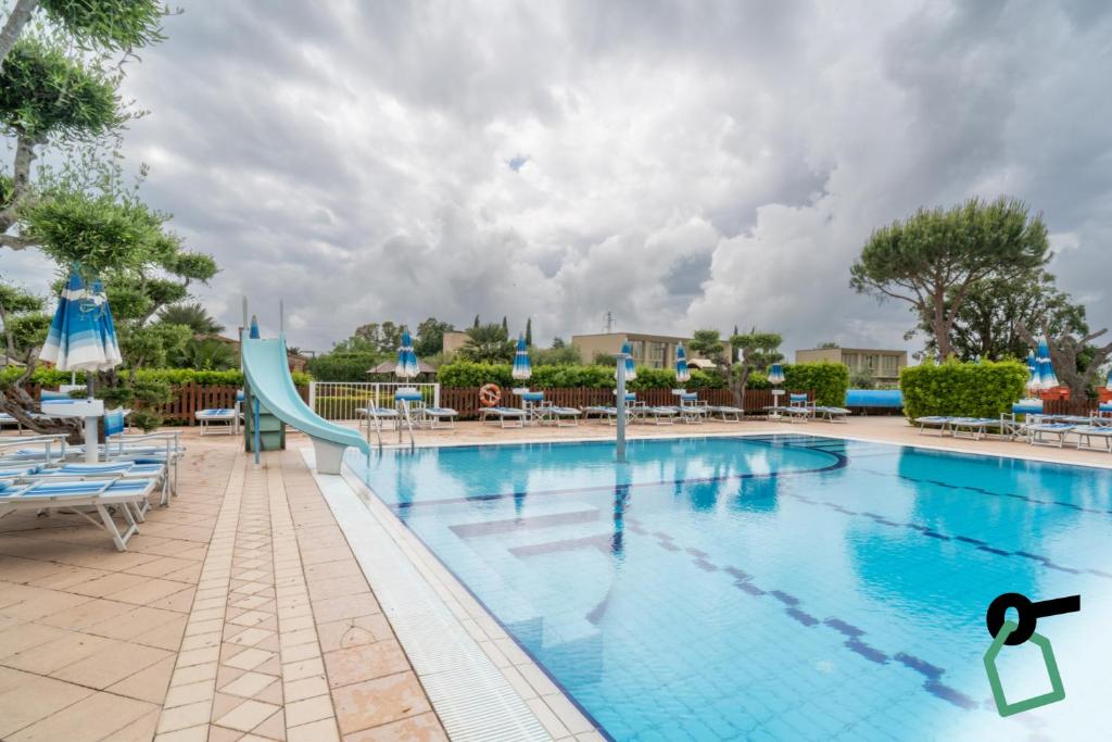 a swimming pool at a resort with a slide at Hotiday Relais Costa degli Etruschi in Vada