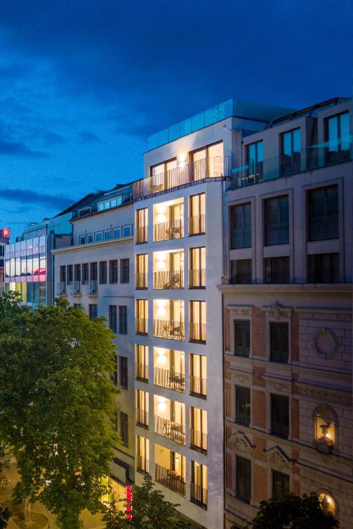 a tall white building with lights on at Kö102 Prime Suites in Düsseldorf