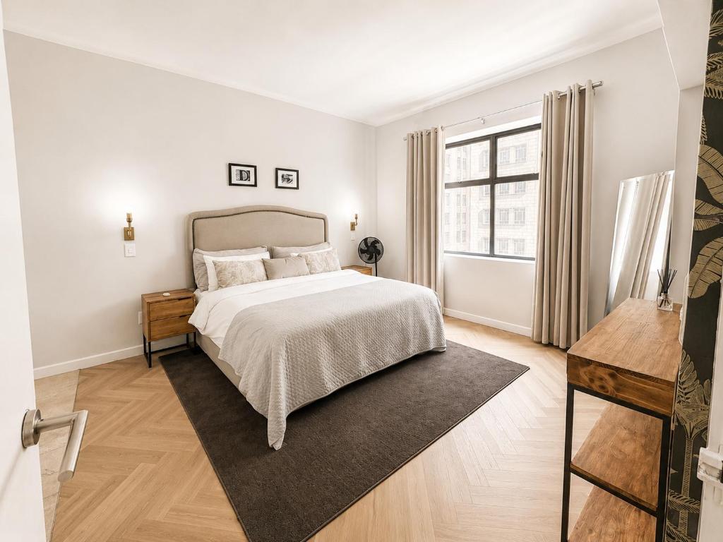 a white bedroom with a bed and a window at Cape Town Panorama Luxe Suite in Cape Town