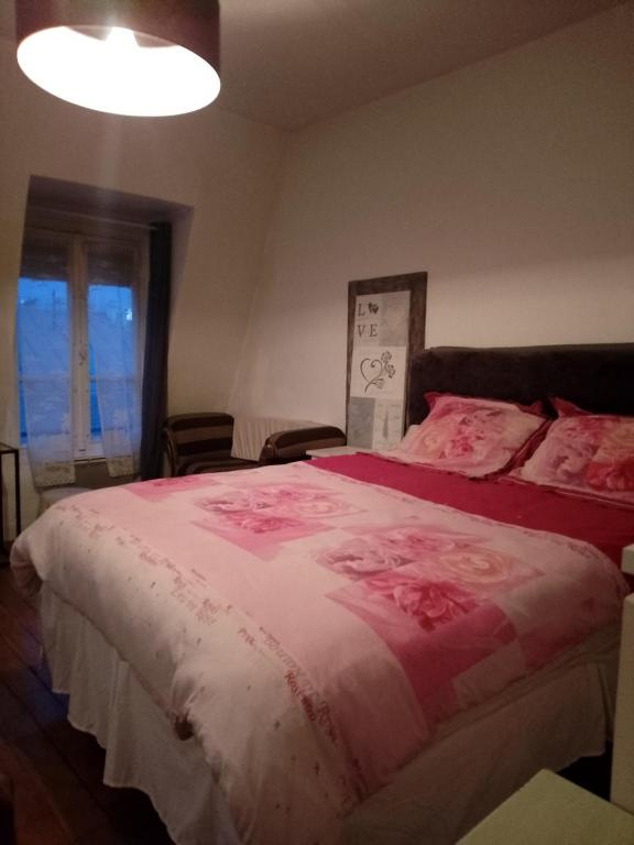 a bedroom with a large bed with pink sheets at Studio pied du métro Neuilly Paris La Défense pour 3 maxi in Neuilly-sur-Seine