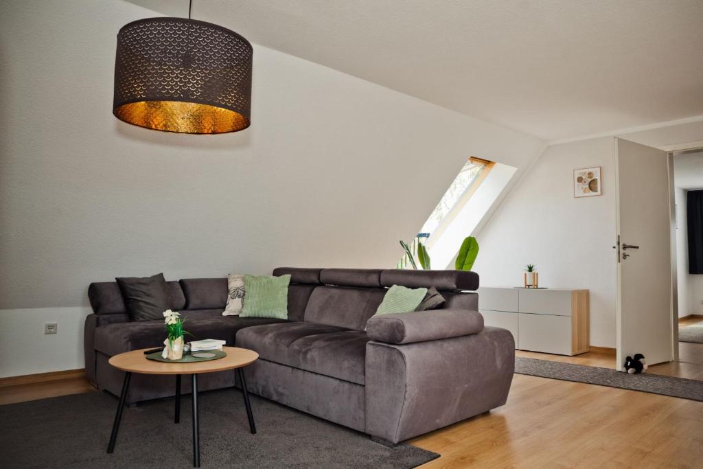 a living room with a brown couch and a table at Henning 2 in Kirchdorf