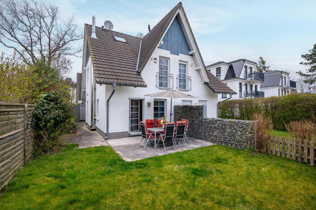 a white house with a table and chairs in the yard at Seestrasse Haus 15 in Zingst