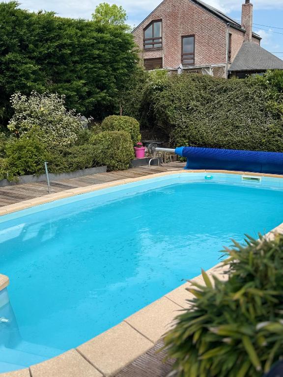 een groot blauw zwembad voor een huis bij Rotonde in Somme-Leuze