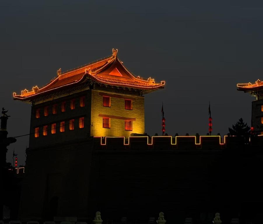 a building with a chinese roof is lit up at night at 璞宿清居民宿 in Xi'an