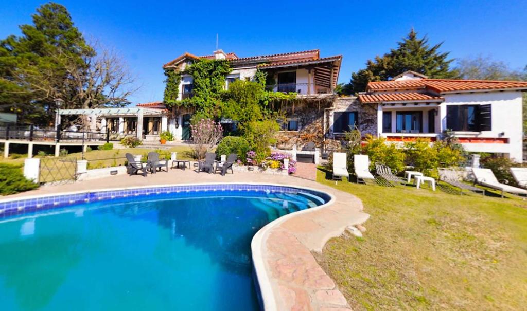 ein Haus mit einem Pool vor einem Haus in der Unterkunft Posada La Villa in Villa Carlos Paz