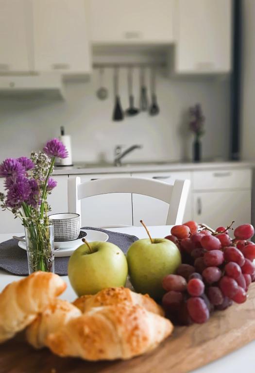 a table with apples and grapes and a plate of bread at apartma Vila TARA in Prebold