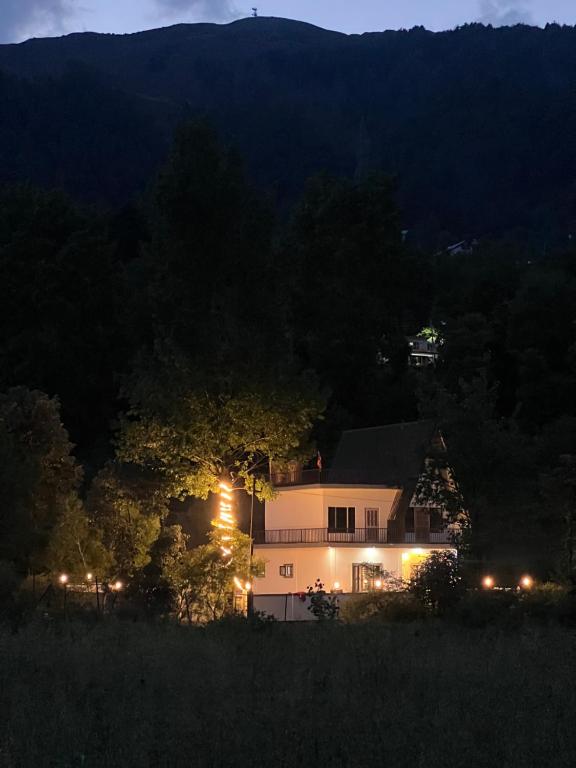 a house lit up at night with lights at Countryside forest village in Udhampur