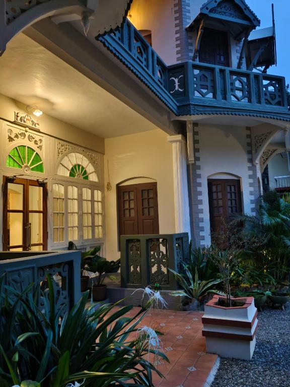 a house with a blue balcony and some plants at Sarada Mandiram A Heritage Hotel in Cochin