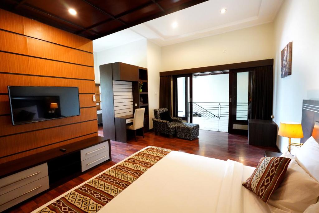 a hotel room with a bed and a tv and a bedroom at The Nakula Villas in Legian
