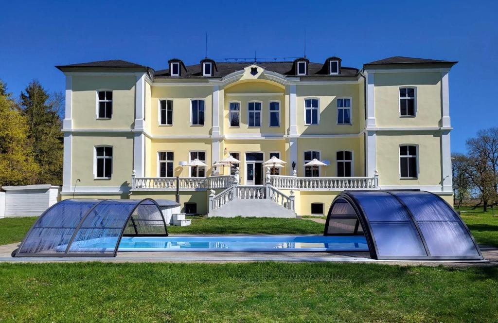 a large white house with two domes in front of it at Schloss Schmuggerow in Schmuggerow