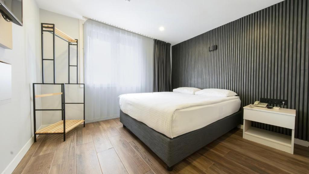 a bedroom with a bed and a black wall at LEGEND TULIP HOTEL in Antalya
