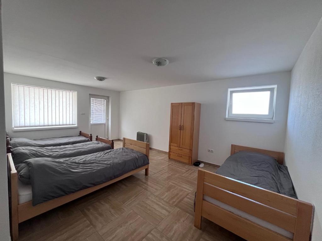 a bedroom with two beds and a wooden floor at Prenoćište TG in Tomislavgrad