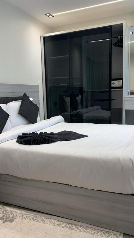 a bedroom with a large white bed with a large mirror at Em banorama abrrtment hotel in Giza