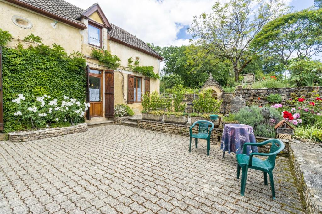a patio with two chairs and a table in front of a house at Gite Périgourdin - 2 Chambres in Saint-Geniès