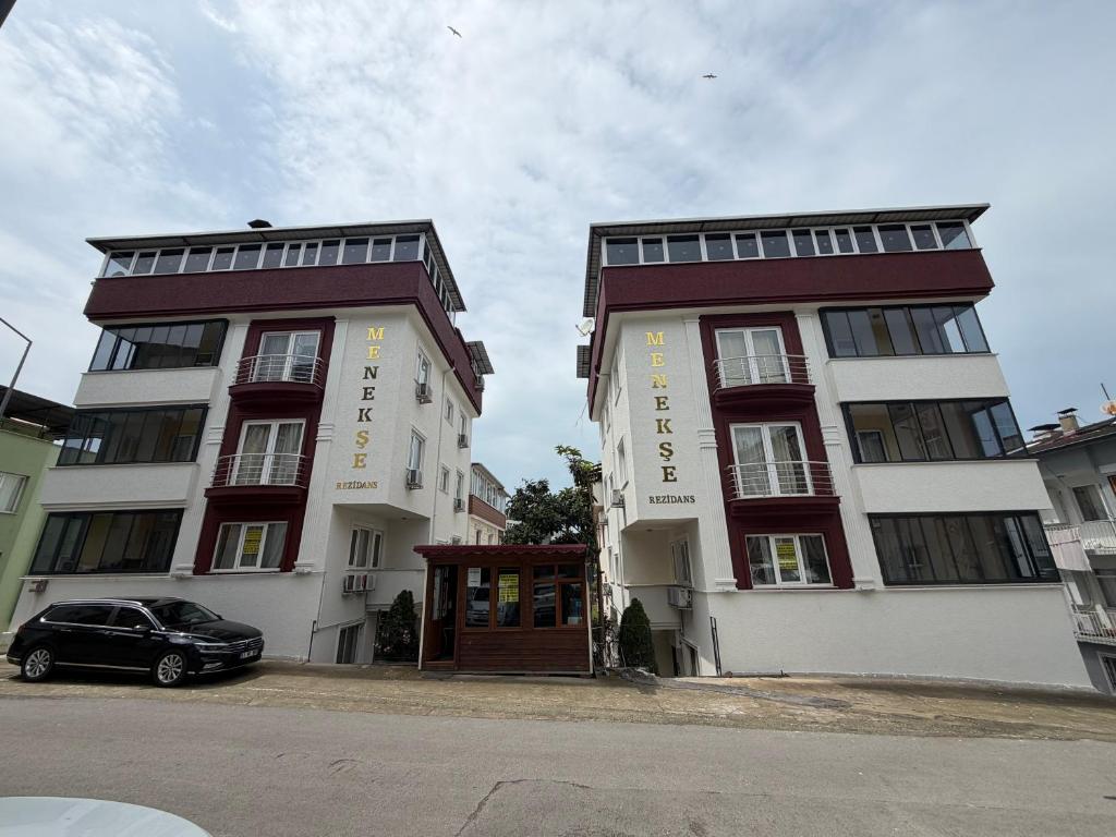 two buildings with a car parked in front of them at Menekşe Apart 1 in Trabzon